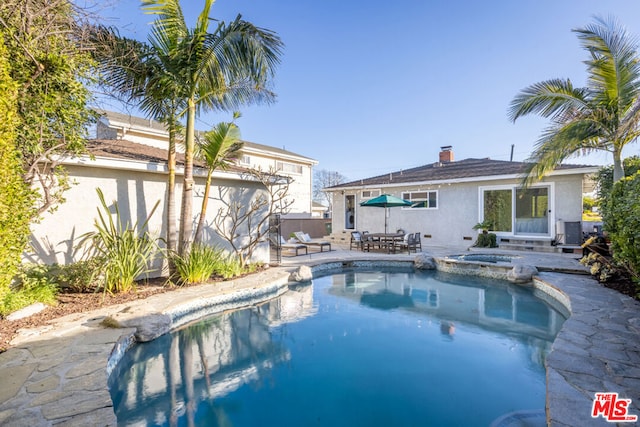 view of pool with central AC, a patio area, and an in ground hot tub