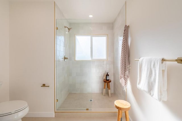 bathroom featuring toilet and a tile shower