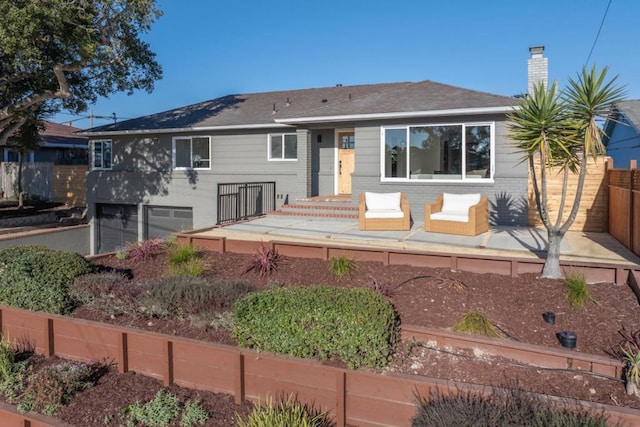 back of property with a garage and a patio area