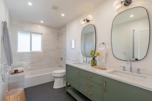 full bathroom featuring vanity, toilet, tiled shower / bath combo, and tile patterned flooring