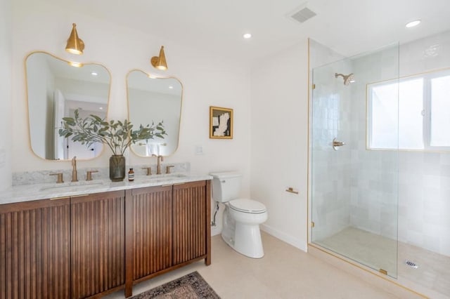 bathroom with vanity, tiled shower, and toilet