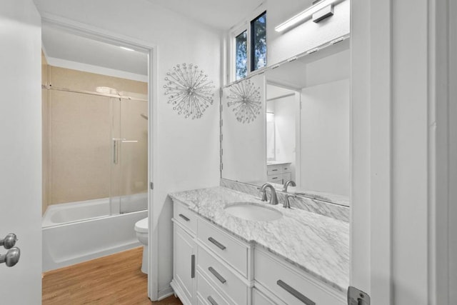 full bathroom featuring toilet, vanity, hardwood / wood-style flooring, and washtub / shower combination