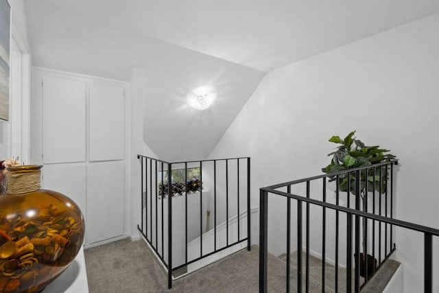 corridor featuring carpet and lofted ceiling