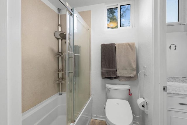 bathroom with toilet, combined bath / shower with glass door, and a wealth of natural light