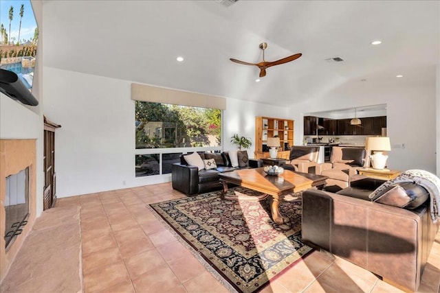 tiled living room with ceiling fan and vaulted ceiling