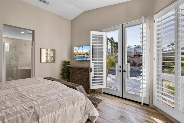 bedroom with light hardwood / wood-style flooring, access to exterior, ensuite bathroom, vaulted ceiling, and french doors