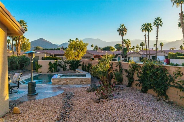 view of yard featuring a mountain view, a patio area, and a pool with hot tub