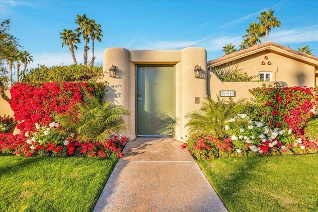 entrance to property featuring a lawn