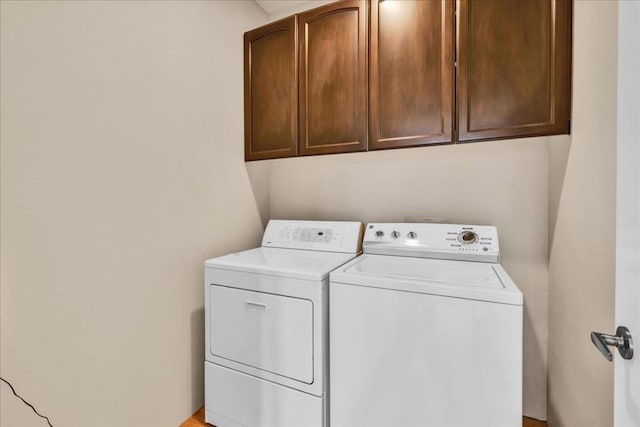 laundry area with washing machine and dryer and cabinets