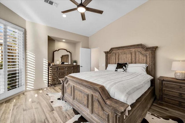 bedroom featuring ceiling fan, lofted ceiling, and light wood-type flooring