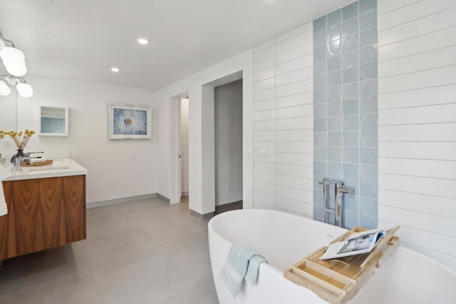 bathroom featuring tile walls, vanity, and a bath