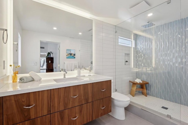 bathroom featuring toilet, vanity, tile walls, and tiled shower