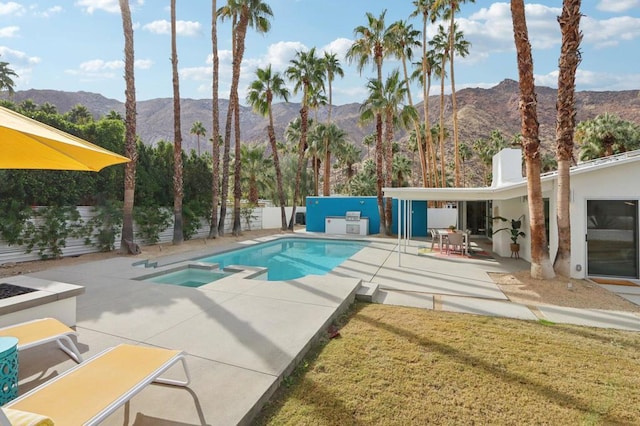 view of pool featuring a mountain view, an in ground hot tub, a lawn, and a patio