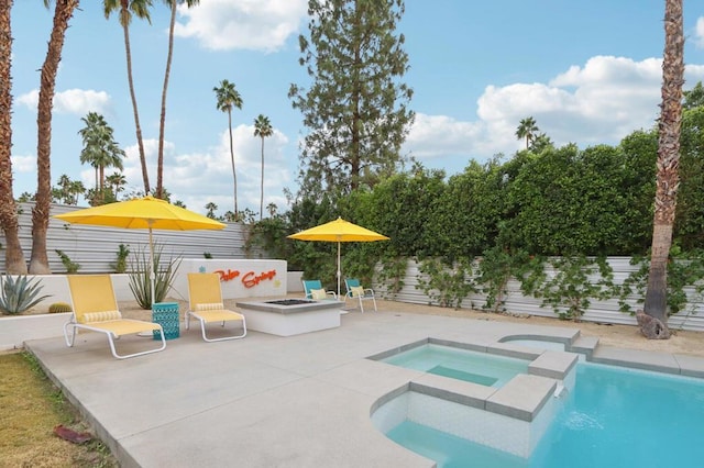 view of swimming pool featuring a patio area, a fire pit, and an in ground hot tub