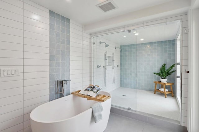 bathroom with separate shower and tub, tile walls, and tile patterned flooring