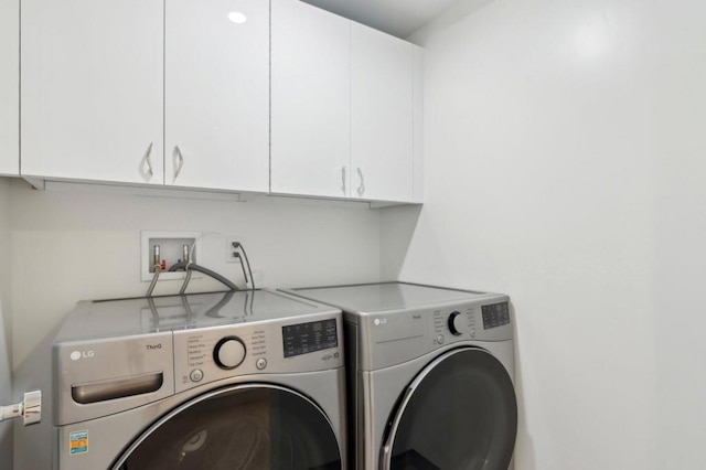 washroom featuring cabinets and independent washer and dryer