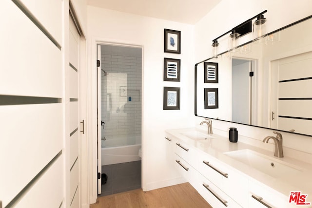 full bathroom with toilet, vanity, tiled shower / bath combo, and hardwood / wood-style floors