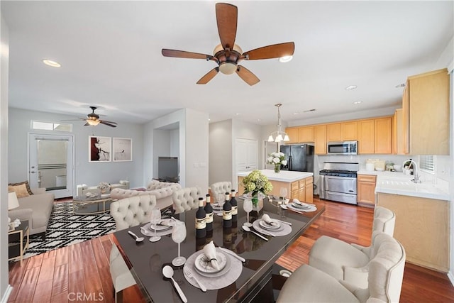 dining room with ceiling fan, sink, and hardwood / wood-style flooring