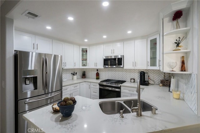 kitchen with white cabinetry, stainless steel appliances, and kitchen peninsula