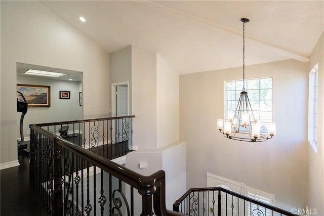 corridor featuring hardwood / wood-style floors, lofted ceiling, and a chandelier