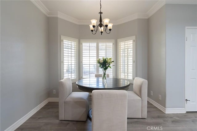 dining room featuring an inviting chandelier, ornamental molding, and hardwood / wood-style flooring