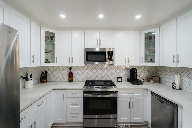 kitchen featuring white cabinets, decorative backsplash, and stainless steel appliances