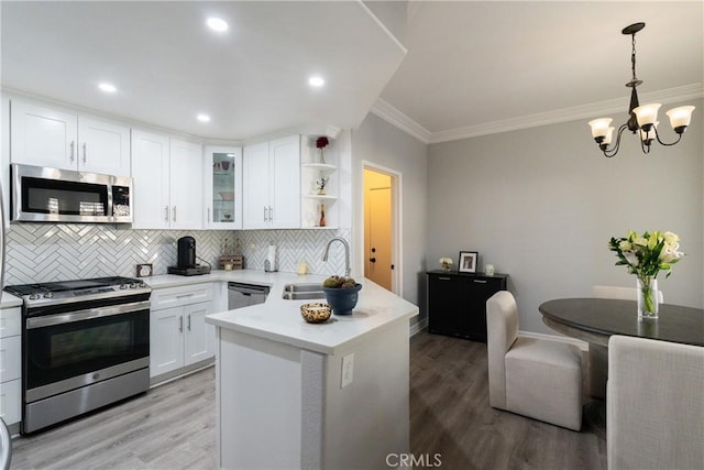 kitchen with stainless steel appliances, decorative backsplash, white cabinetry, and sink