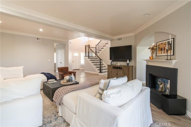 living room featuring light wood-type flooring and ornamental molding