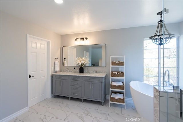 bathroom with a washtub, vanity, and a chandelier