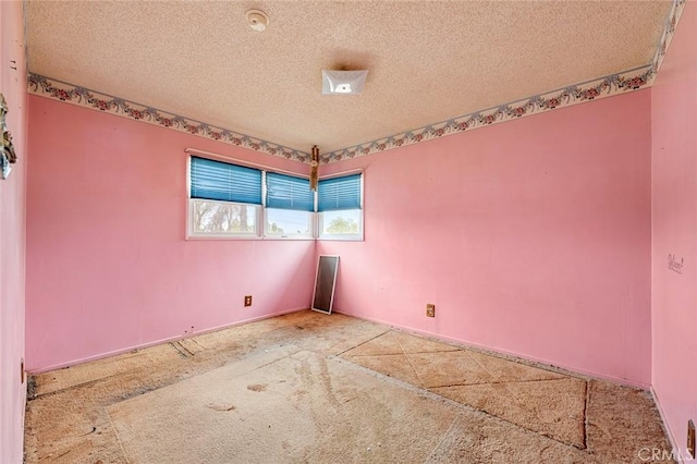 unfurnished room with a textured ceiling