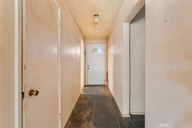 hall featuring a textured ceiling