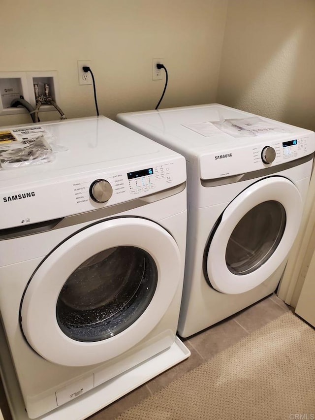 washroom with light tile patterned floors and separate washer and dryer