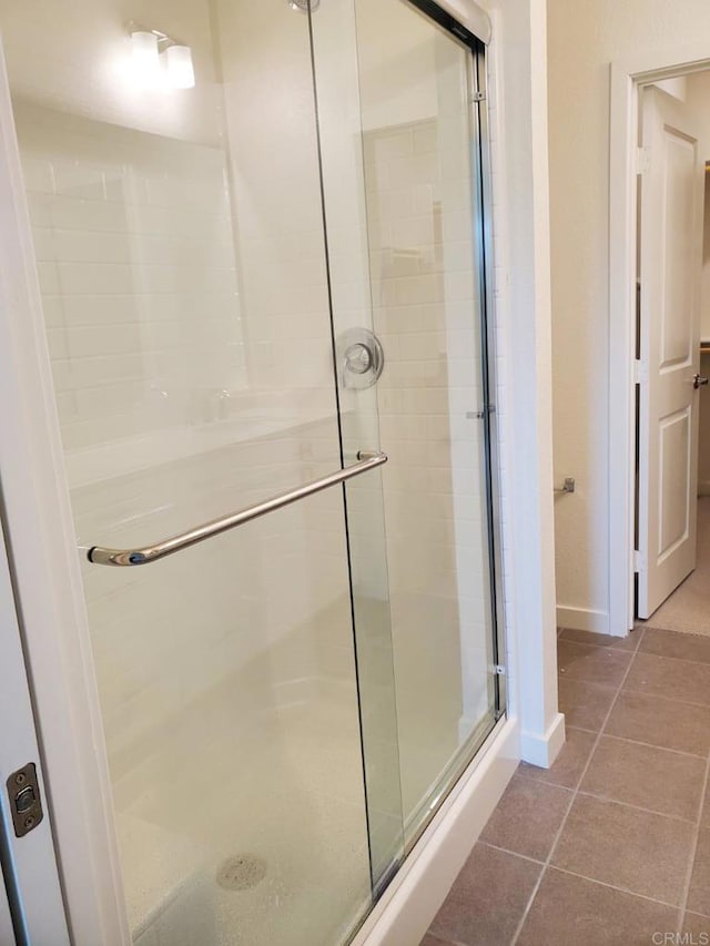 bathroom with tile patterned flooring and a shower with door