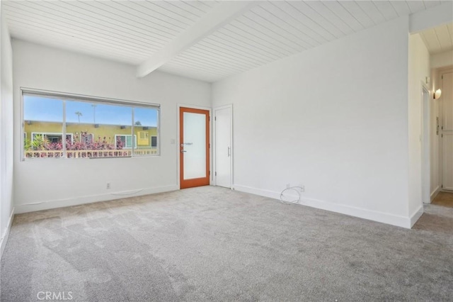 carpeted empty room with beam ceiling