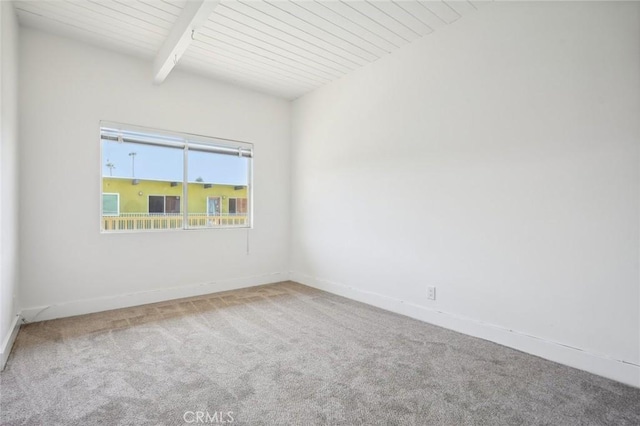 carpeted empty room featuring beam ceiling