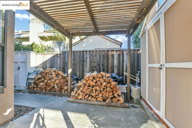 view of patio featuring a pergola and a storage unit