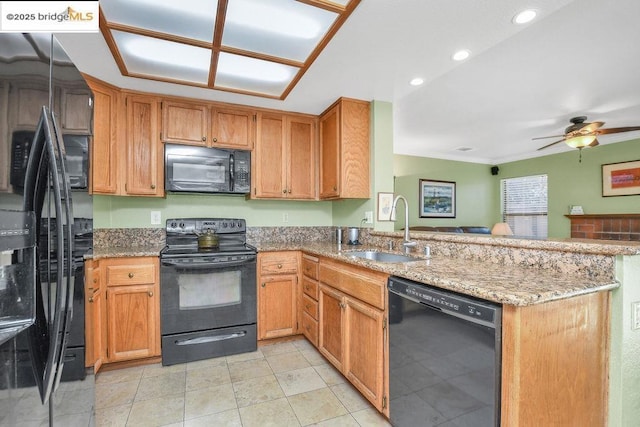 kitchen with black appliances, ceiling fan, sink, kitchen peninsula, and light stone counters