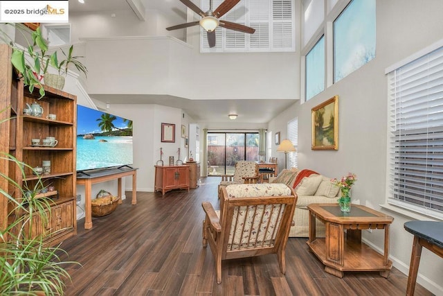 interior space featuring ceiling fan, a towering ceiling, and dark hardwood / wood-style floors