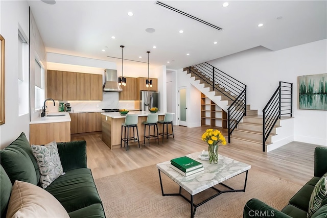 living room with sink and light hardwood / wood-style flooring