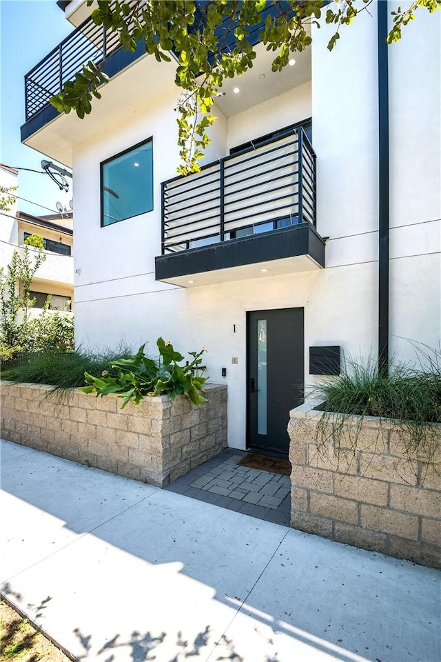 view of exterior entry with a balcony