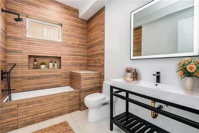 bathroom with toilet, tile patterned floors, tiled shower, and sink