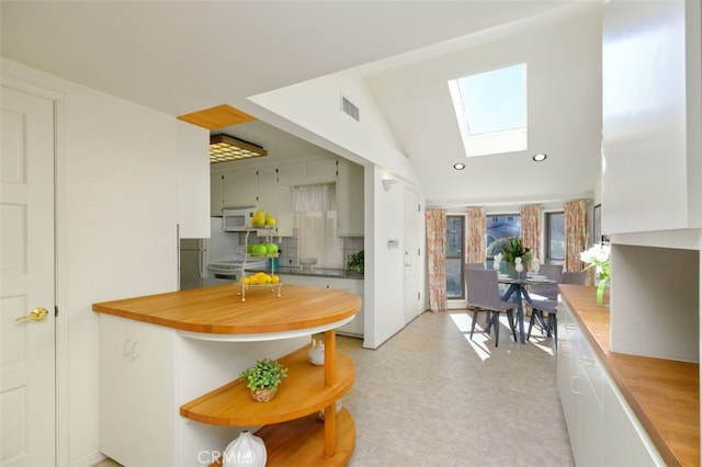 kitchen featuring stove and lofted ceiling with skylight