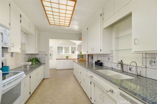 kitchen with sink, white appliances, white cabinetry, backsplash, and light stone countertops