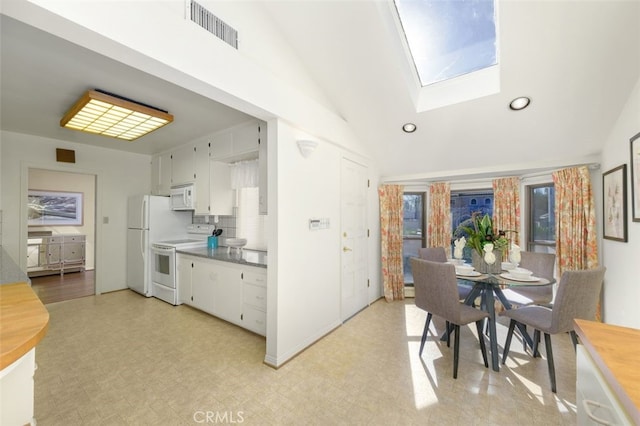 dining area featuring lofted ceiling with skylight