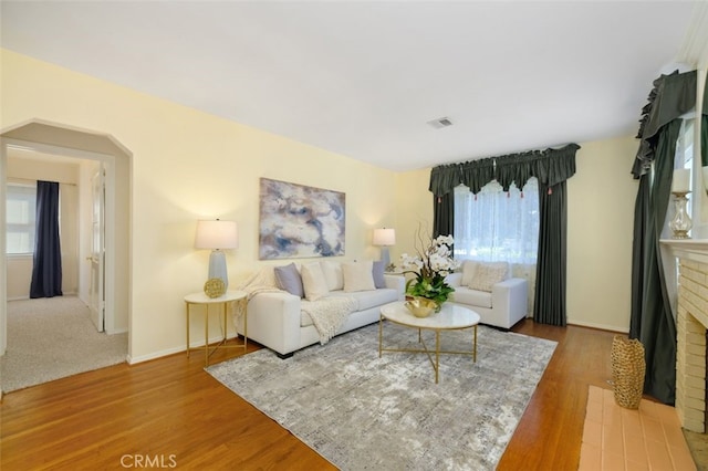 living room with a fireplace and light wood-type flooring