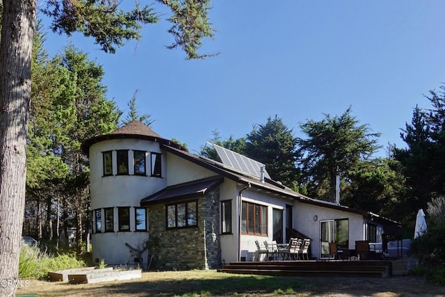 view of front of home with a deck and solar panels