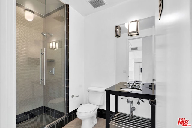 bathroom with sink, toilet, a shower with door, and tile patterned flooring