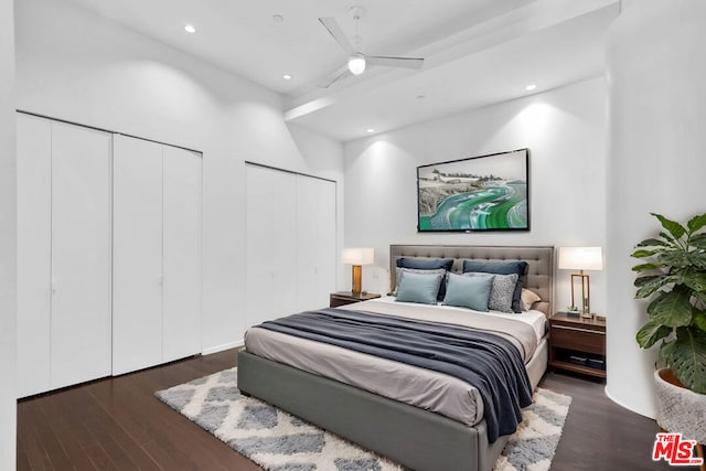 bedroom featuring ceiling fan, dark hardwood / wood-style floors, and multiple closets