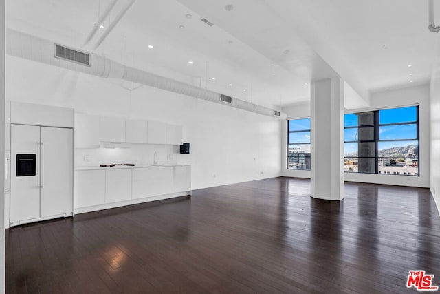 unfurnished living room featuring dark wood-type flooring and sink