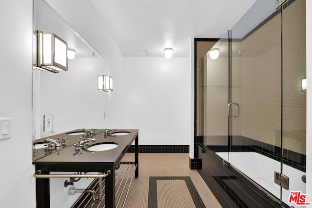 bathroom featuring sink and shower / bath combination with glass door